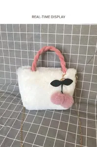 Detail view of cute white faux fur handbag with pink cherry charm and gold chain strap