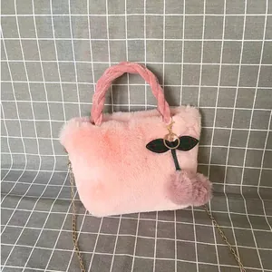 Detailed view of a soft pink faux fur cherry handbag featuring a golden chain strap