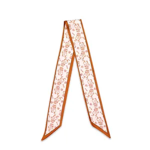 Detail of narrow decorative scarf with cute orange cow pattern for hair or bag handle