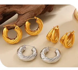 Detailed macro view of multiple gold and silver twisted C-shaped fashion hoop earrings