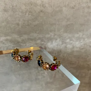 Close-up of vintage court style multicolored crystal stud hoop earrings on acrylic