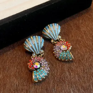 Close-up of vintage palace style shell earrings decorated with colorful rhinestones
