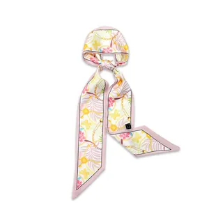 Close-up detail of an elegant narrow floral silk scarf with butterfly and chain patterns.
