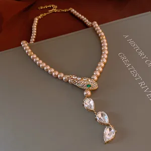 Close-up detail of vintage palace style necklace featuring rhinestone snake head and pearls