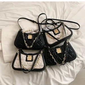 Close-up view of elegant quilted leather crossbody and underarm bags with gold chain straps