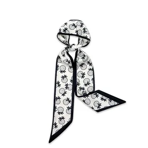 Detailed macro view of a thin white narrow scarf with black strawberry print pattern