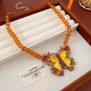 Detailed view of a vintage palace style butterfly necklace with amber beads
