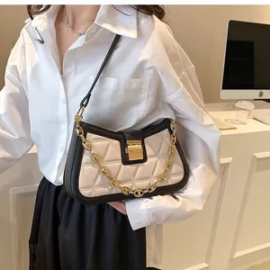 Elegant quilted crossbody bag in black and white leather with gold chain strap detail.