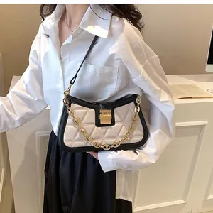 Detail showing fashionable white quilted crossbody bag with elegant gold chain strap