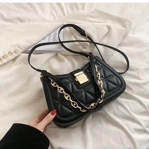 Close-up of a stylish black quilted handbag featuring a luxury gold chain strap detail