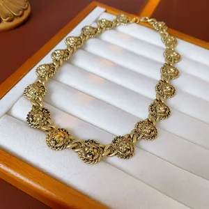 Detailed view of a vintage gold-toned lion head statement necklace on a jewelry tray