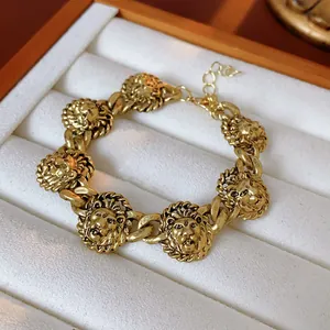 Detailed close-up of a vintage court style gold lion head charm bracelet in a box