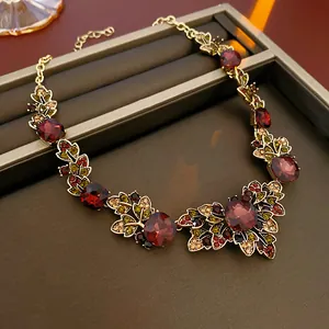 Close-up of luxury vintage court style necklace featuring red crystals and golden leaves