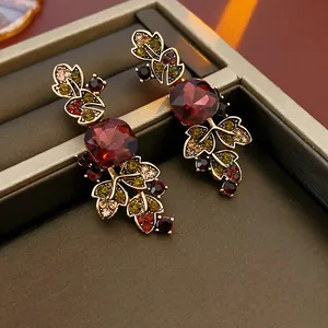 Close-up of vintage style gold-tone earrings with red and multi-colored rhinestones