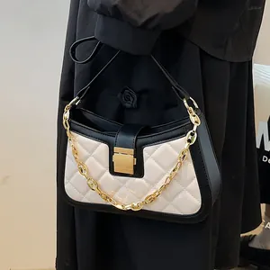 Elegant black and white quilted underarm shoulder bag featuring a decorative gold chain