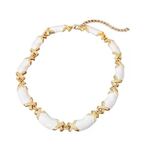 Vintage gold and white enamel choker necklace with iconic X-shaped cross motifs.