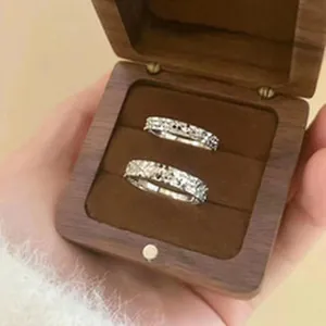 Macro view of shimmering s925 silver rings set in a minimalist wooden gift box