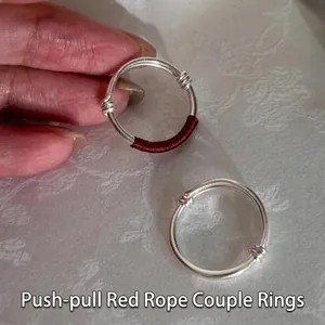 Close-up of minimalist S925 silver rings with unique red thread detail