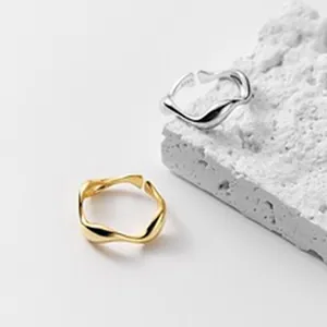 Macro view of irregular wave-shaped S925 sterling silver rings in gold and silver