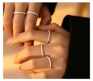 Close-up of sparkling s925 sterling silver textured dainty rings worn on fingers