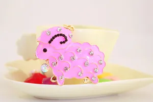 Detailed view of a cute pink enamel sheep keychain adorned with sparkling rhinestones.