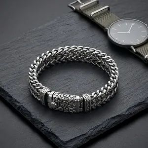 Detail of men's punk style titanium steel dragon bone chain bracelet on slate