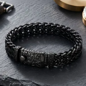 Macro detail of a punk style black titanium steel dragon bone chain bracelet with ornate clasp.