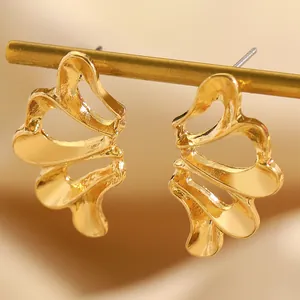 Vue détaillée de boucles d'oreilles dorées en forme d'éventail avec texture ondulée chic.