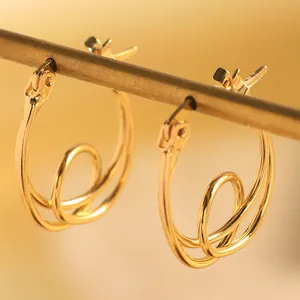 Gros plan détaillé des élégantes boucles d'oreilles créoles dorées géométriques
