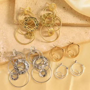 Détail de boucles d'oreilles pendantes multicouches martelées et créoles en or et argent