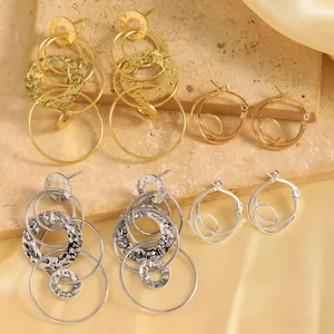 Détail de boucles d'oreilles à cercles martelés élégants en finitions or et argent