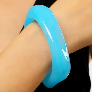 Detailansicht eines blauen marmorierten Harzarmreifens mit unregelmäßigem Design.