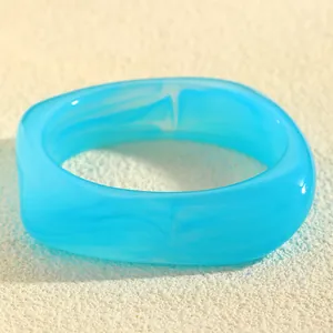 Modern irregular geometric resin bangle featuring a blue marble swirl pattern effect