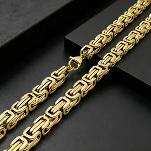 Macro detail shot showing the intricate links of a heavy gold Byzantine chain necklace for men