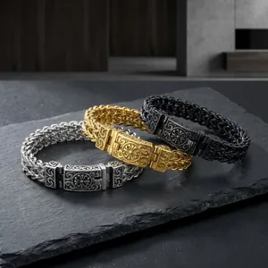 Primo piano delle chiusure in metallo goffrato su tre bracciali in acciaio intrecciato