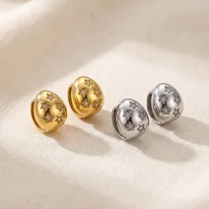 Close-up of gold and silver stainless steel teardrop earrings with star engravings