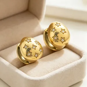 Macro view of 18K gold plated stainless steel star stud earrings with inlaid crystals.