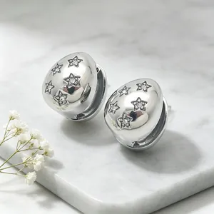 Close-up of teardrop earrings featuring sparkling rhinestone stars