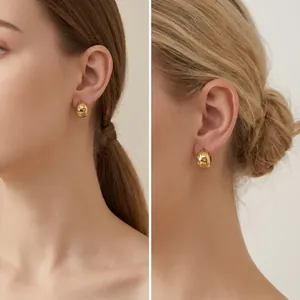 Detailed shot of 18K gold plated stainless steel star earrings on a female model