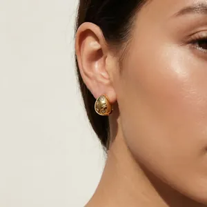 Close-up of 18K gold plated stainless steel teardrop earrings with star engravings.