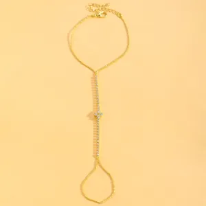 Elegant gold-tone finger bracelet featuring a vertical rhinestone chain and flower motif.