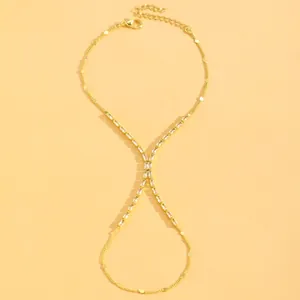 Detailed view of gold finger bracelet with elegant baguette crystals on yellow background