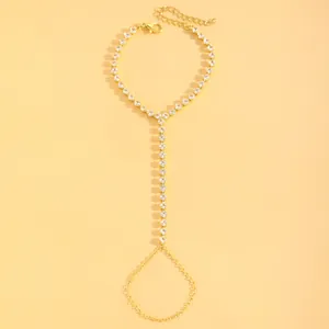 Elegant gold finger bracelet with sparkling rhinestones on yellow background