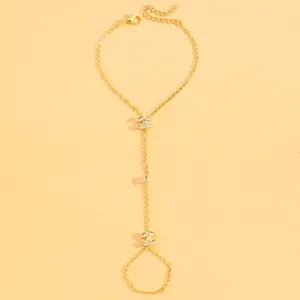 Detailed view of an elegant gold-toned hand chain bracelet featuring crystal-embellished accents