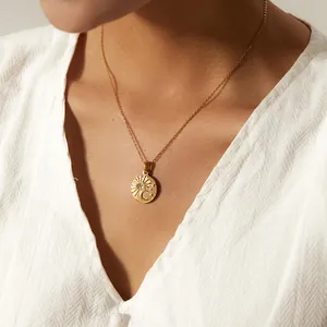Primo piano di una collana con ciondolo sole e luna in acciaio dorato su una modella