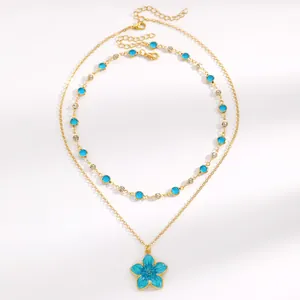 Detail of gold-tone double-layered necklace with turquoise flower pendant