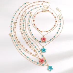 Detailed view of gold-tone necklaces with colorful crystals and oil-drop flower pendants.