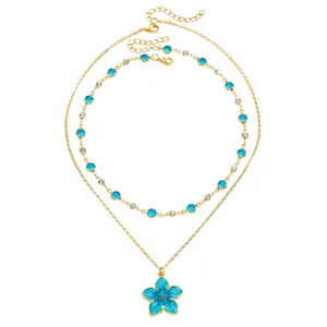 Close-up of double-layer necklace with blue enamel flower and crystal accents