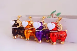 Vue détaillée de quatre porte-clés mouton en émail coloré avec des colliers en strass brillants.