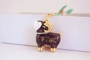 Vue macro détaillée d'un porte-clés mouton en émail noir avec des accents dorés